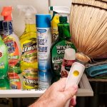 man is reaching in his utility closet for broom dustpan and cleaning supplies to clean his condo t20 29dzxK