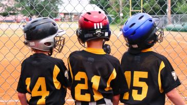 baseball teammates three boy talking and waiting for they turn to play baseball safety first with t20 3JRVZ3